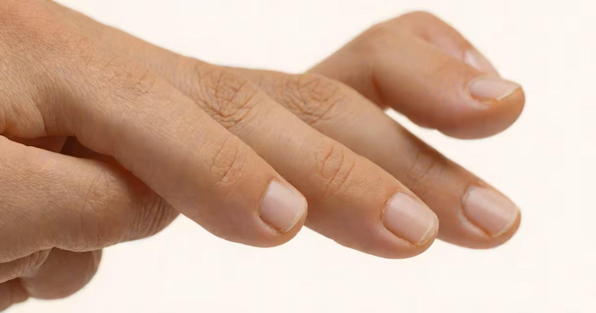 Close-up of a hand with a slightly twitching middle finger, natural lighting, neutral background